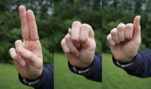 The letters “U,” “N” and “A” being spelled in American Sign language.